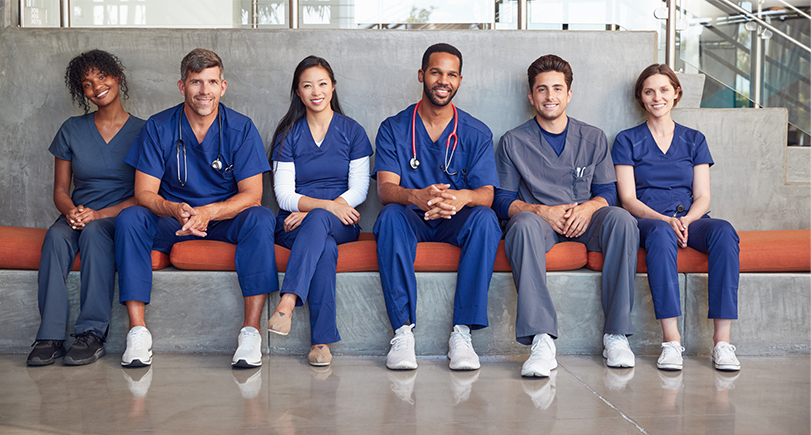 a group of doctors and medical staff sitting on a bench