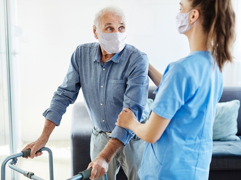 a nurse helping an elderly person walk
