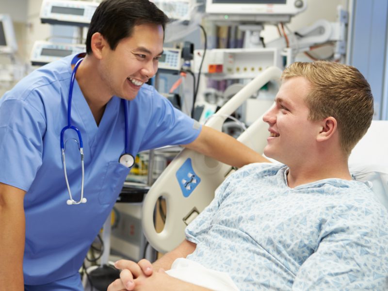 Young Male Patient Talking To Male Nurse In Emergency Room
