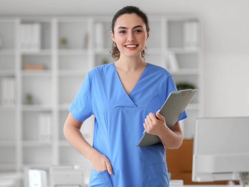 Female medical assistant with clipboard in clinic