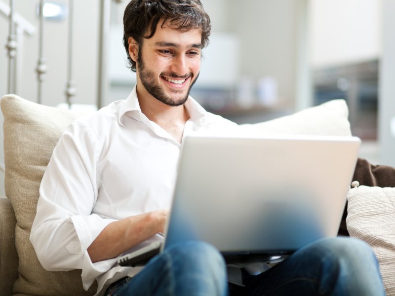 Young man relaxing on the sofa with a laptop