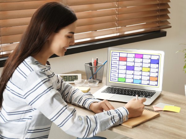 Young woman planning her schedule with calendar app on laptop in office