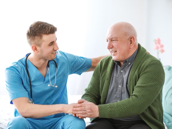 Medical worker with senior man in nursing home