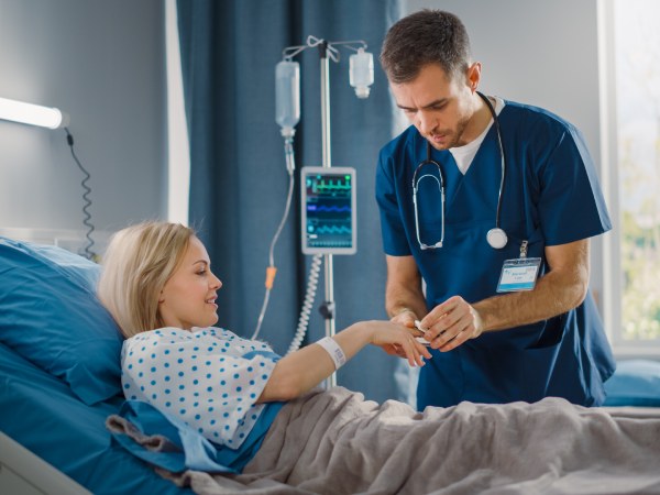 Hospital Ward: Friendly Head Nurse Connects Finger Heart Rate Monitor 